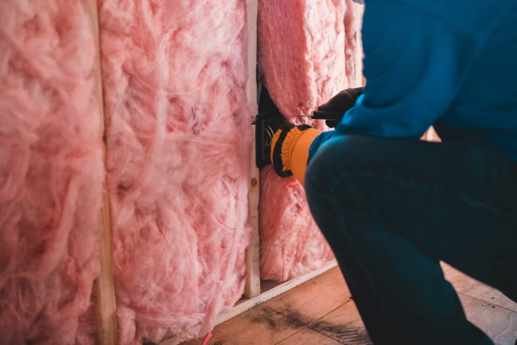 Attic Man insulation tech cutting fiberglass insulation to fit perfectly